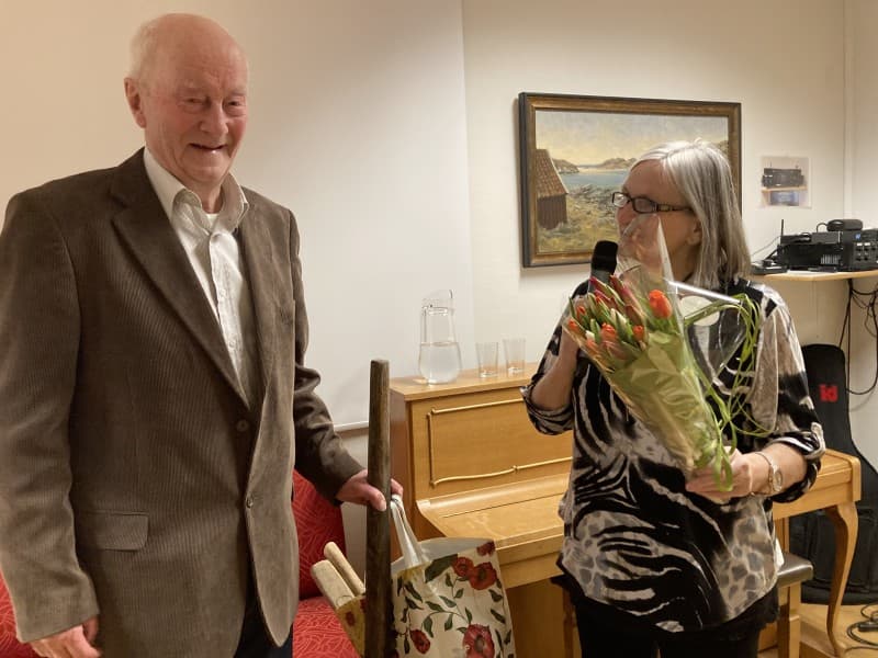 Reidun Westergren takker og overrekker tulipaner til  lokalhistoriker Jostein Andresen. 