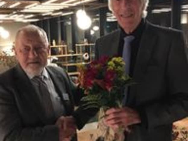 Finn-Åge Løvlien får blomster av formannen i Hedmark Pensjonsiforbund.